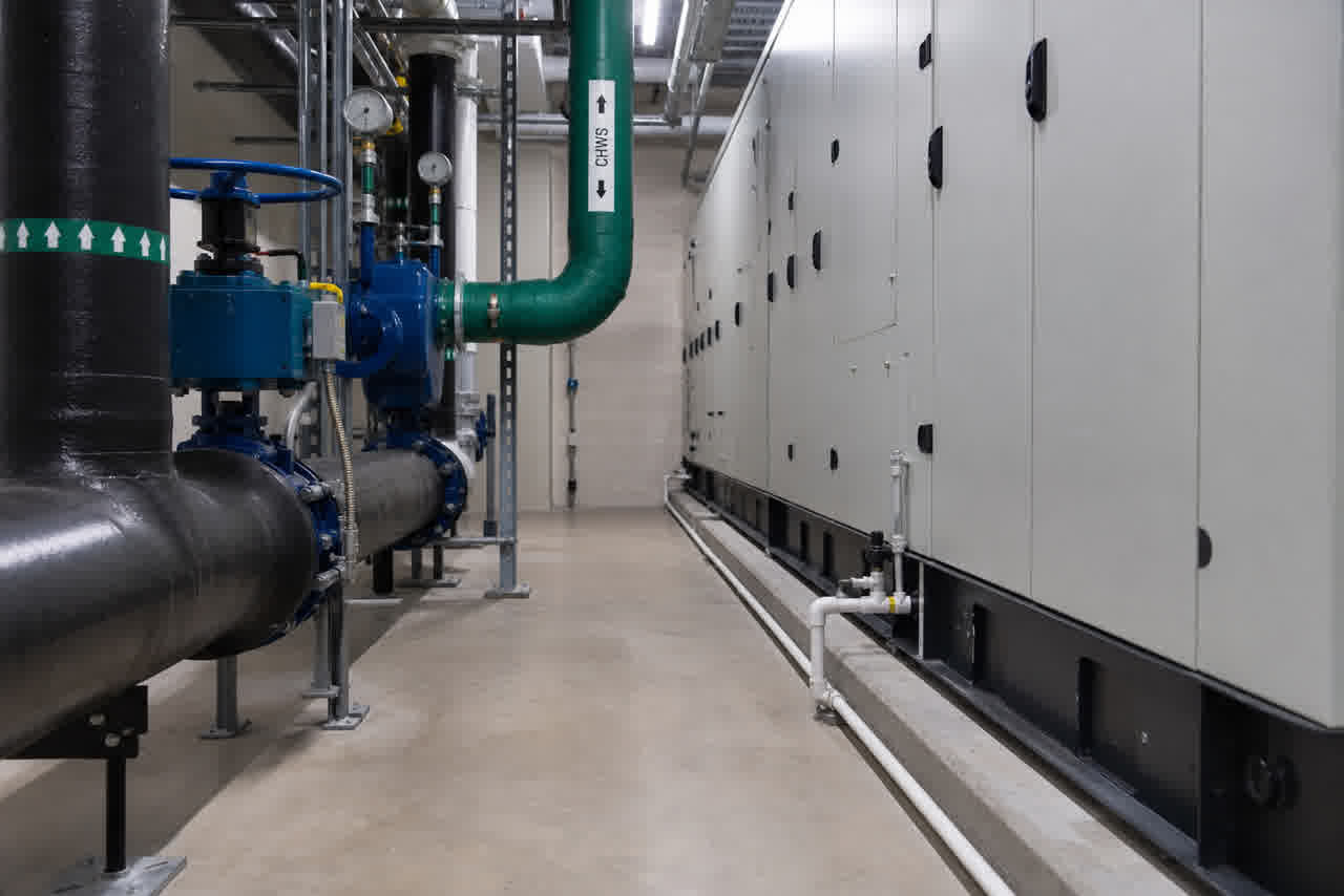Perimeter CRAH unit with chilled-water piping in a data-center mechanical gallery